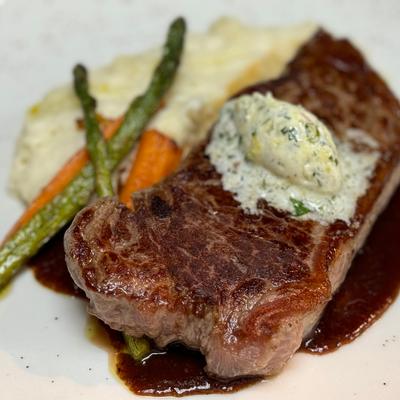 Brandt Beef New York Steak, mashed potatoes, roasted baby carrots & asparagus, compound butter.