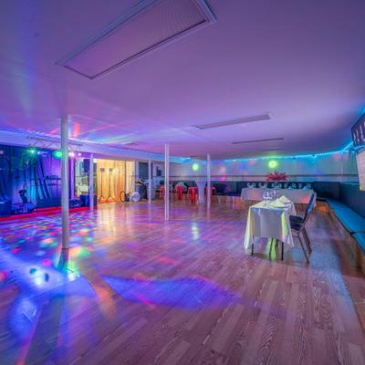 An indoor space decorated with colorful lights, set up as a venue for events.