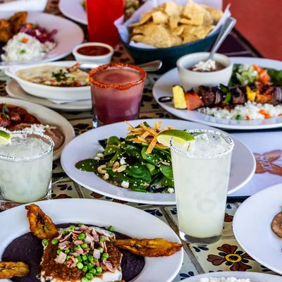 A variety of dishes and cocktails on a table.