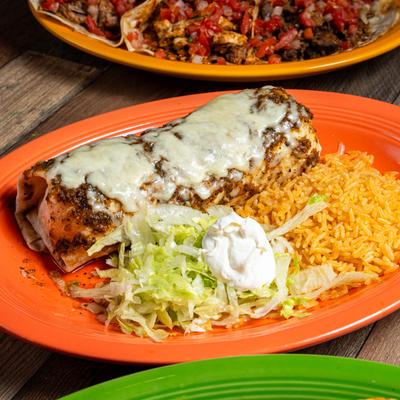 El Borracho Burrito served with rice, shredded lettuce, and sour cream.