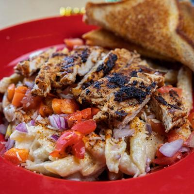 Grilled Chicken Pasta with vegetables, served with a toast.