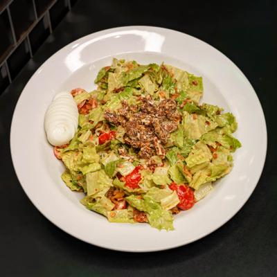 Salad with lettuce, boiled eggs,  bacon bits, tomato, candied pecans, and honey mustard dressing.