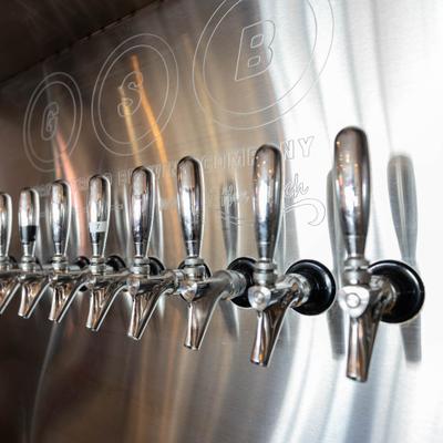 Beer taps mounted on a stainless steel wall.