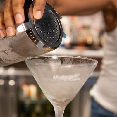 Bartender pouring a cocktail.