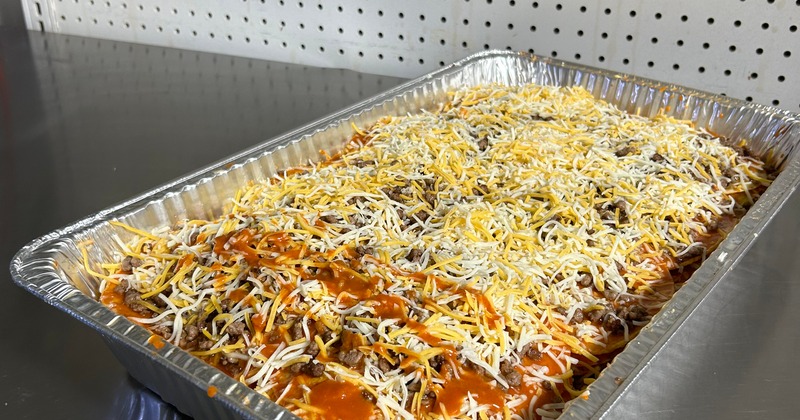 Cheesy casserole prepared in an aluminum tray