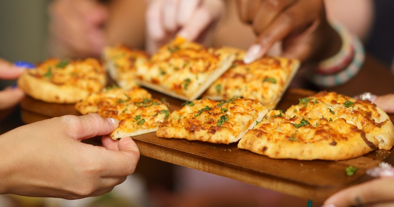 Two dishes served in to-go containers and a can of Guinness