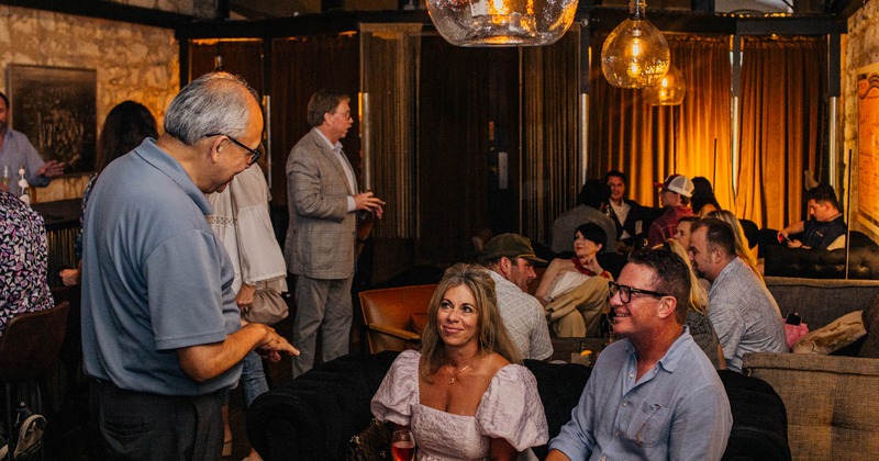 Guests socializing in a warmly lit lounge