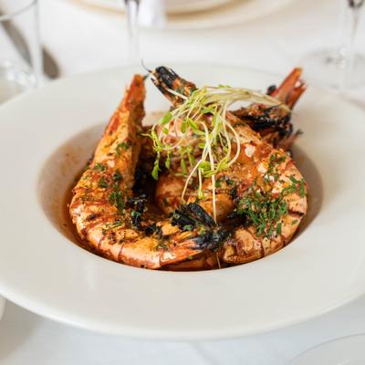 Grilled prawns with herb garnish.