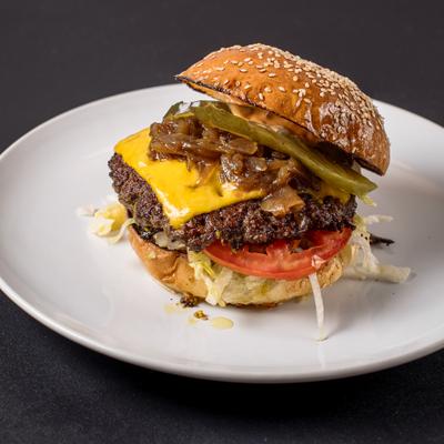 Cali Burger with caramelized onions, sliced pickles, lettuce and tomato.