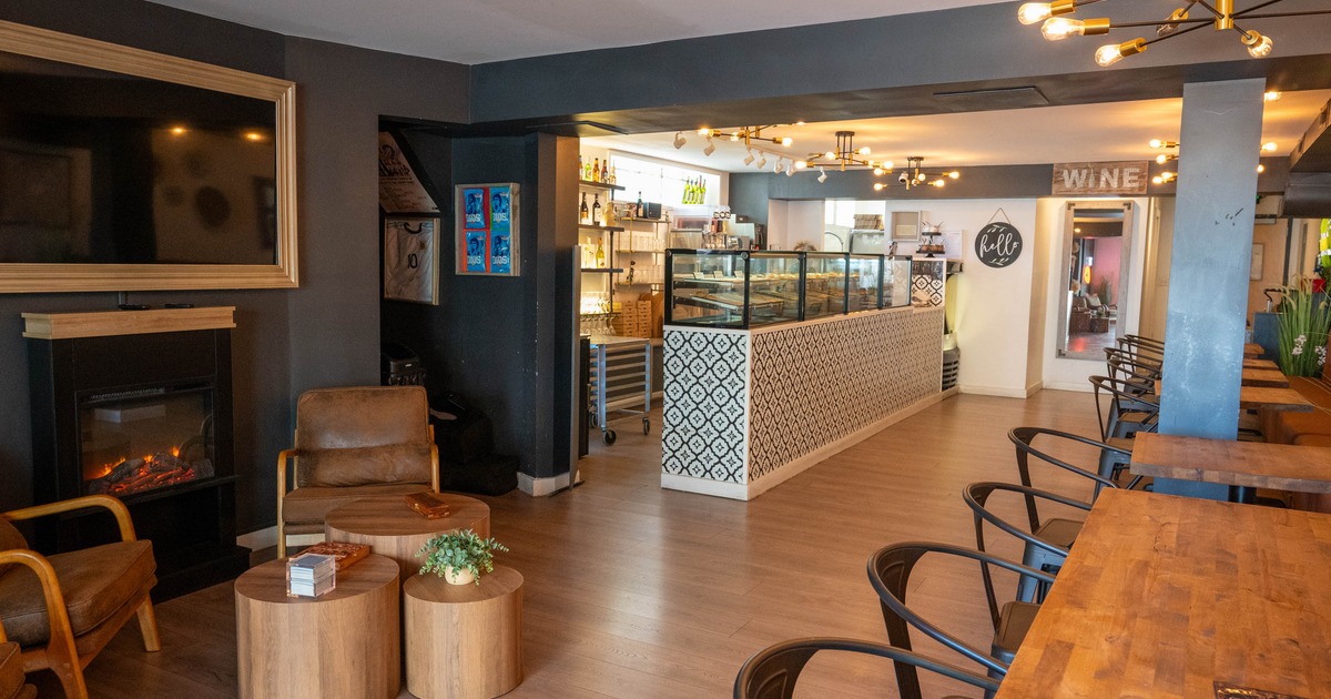Cozy interior - leather seating, a faux fireplace, wooden tables, a tiled counter with display cases