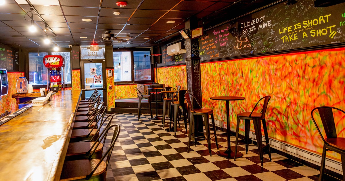Interior, bar with a colorful, abstract decor, a long wooden bar top, checkered floor, wall art