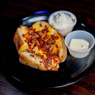 Loaded baked potato served with condiments.