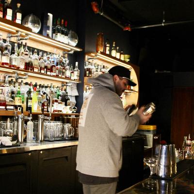Bartender making a cocktail behind the bar.