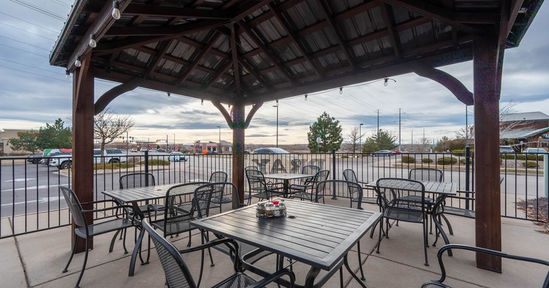 Exterior, covered seating area, pergola, tables for four, metal railing, concrete flooring