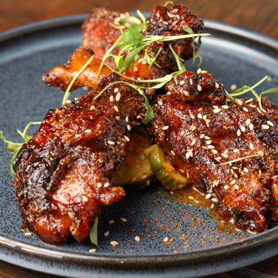 Gazed and spiced chicken wings served over sliced cucumbers.