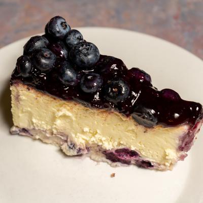Slice of Blueberry cheesecake topped with fresh blueberries.