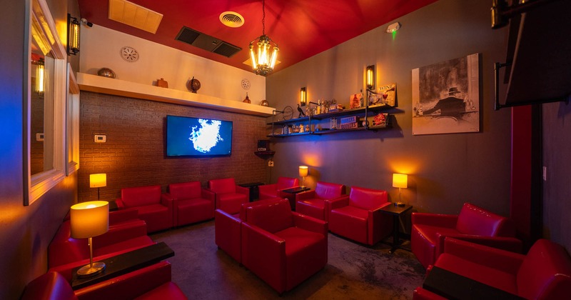 Interior, lounge area, armchairs, dim light, shelves with various decoration, TV on the wall