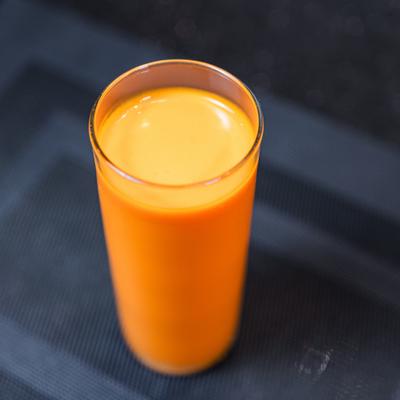 Mango lassi served in a tall glass.