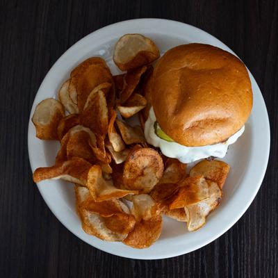 Cheeseburger, with smoked pork belly, BBQ sauce, pickles, mayo, and potato chips.