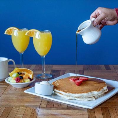Pancakes, fruit salad and two orange juices on the side