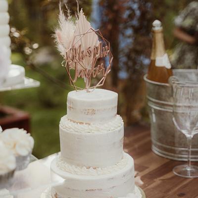 White cake and a champagne bucket on a table at an event.