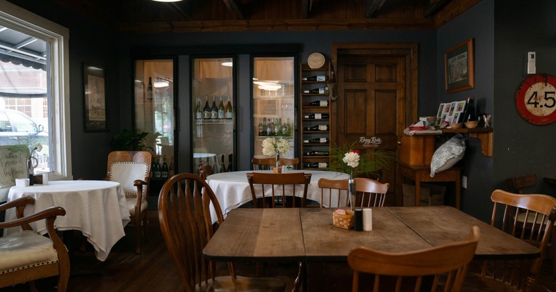 Cozy café interior with wooden furniture, round tables with white tablecloths