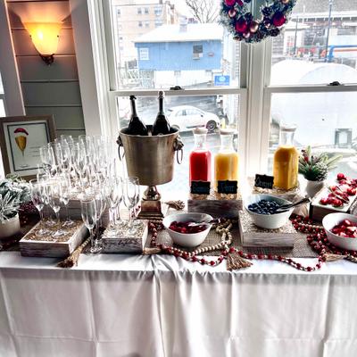 Mimosa bar with flutes, bottles of champagne, ice bucket and carafes of juice.