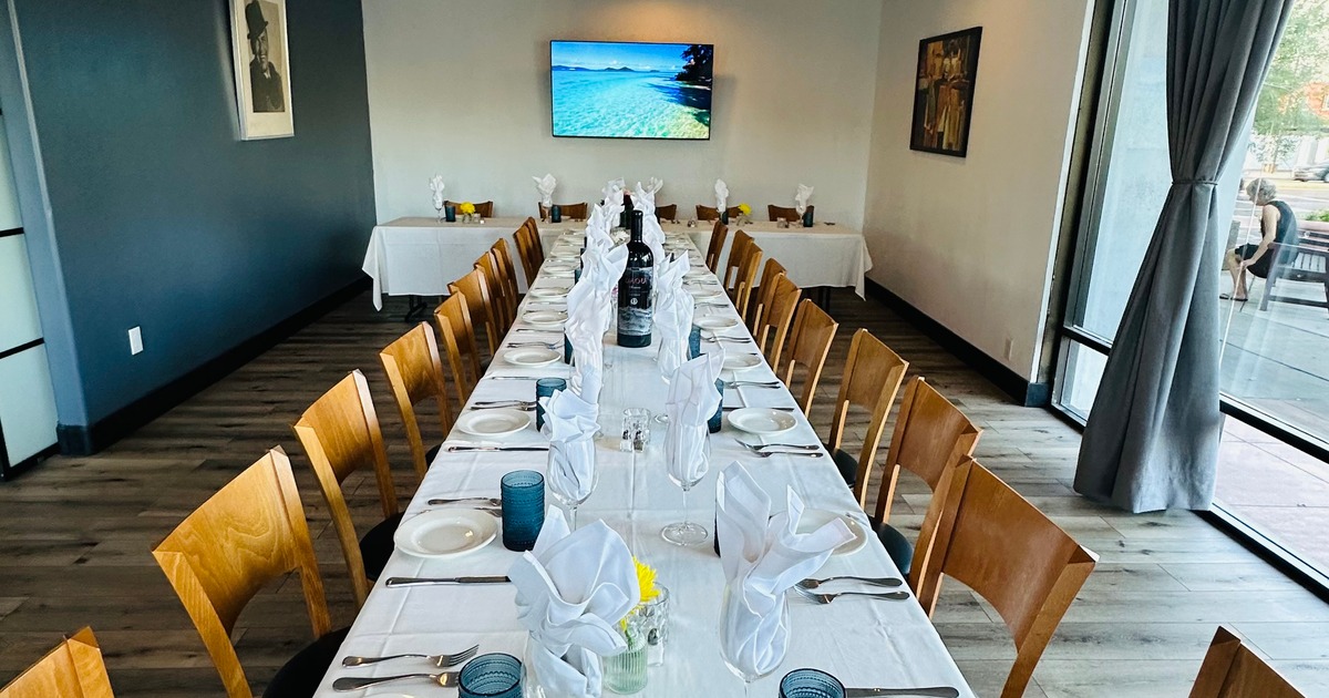 Long table with chairs, place settings and glassware