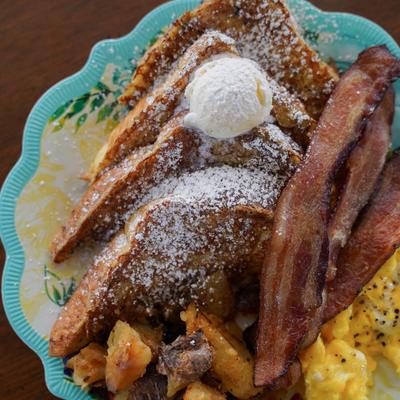 185 Plate with scrambled eggs, French toast, bacon, and smashed potatoes.