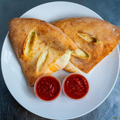 Three Cheese Calzones, served with marinara sauce.