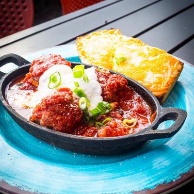 Meatballs in sauce paired with cornbread.