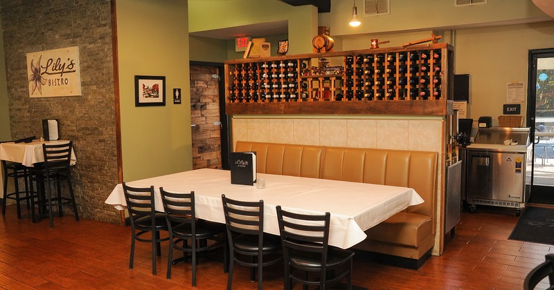 Interior, single booth seating with table and chairs, wine rack