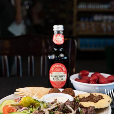 Combination Platter with  Greek salad, gyro, falafel balls, pita, tomatoes and cherry cola.