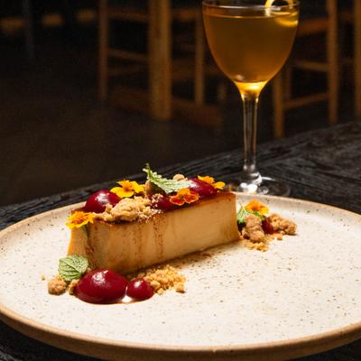 Plated dessert served alongside a cocktail in Nick and Nora glass.