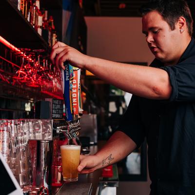 A bartended pouring draft beer.