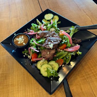Steak salad with blue cheese crumbles, pickled red onions, cucumber and tomatoes.