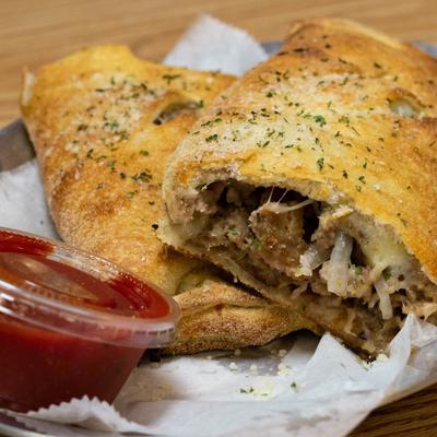 Philly Cheese steak stromboli served with a dipping sauce.