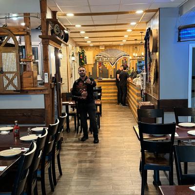 Restaurant interior with wooden decor, staff members.