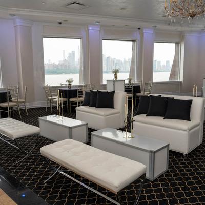 Lounge area with white sofas and black pillows.