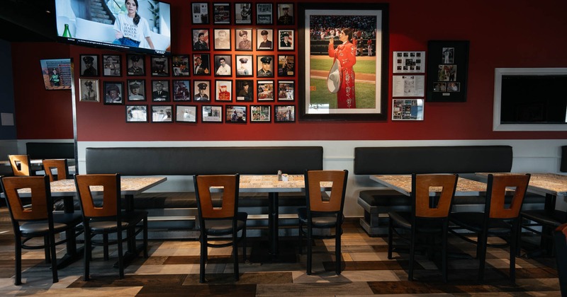 A seating area, tables along the photo wall and a large TV screen