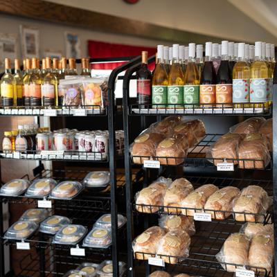 Dsplay rack with loaves of bread, bottled drinks, and packaged items.
