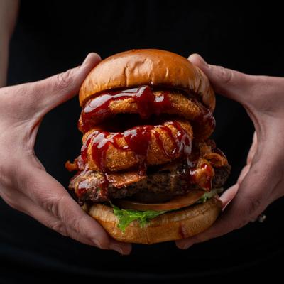 Hands holding the Texas burger.