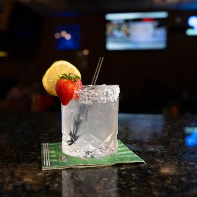 Pale cocktail  with lemon and strawberry garnish.
