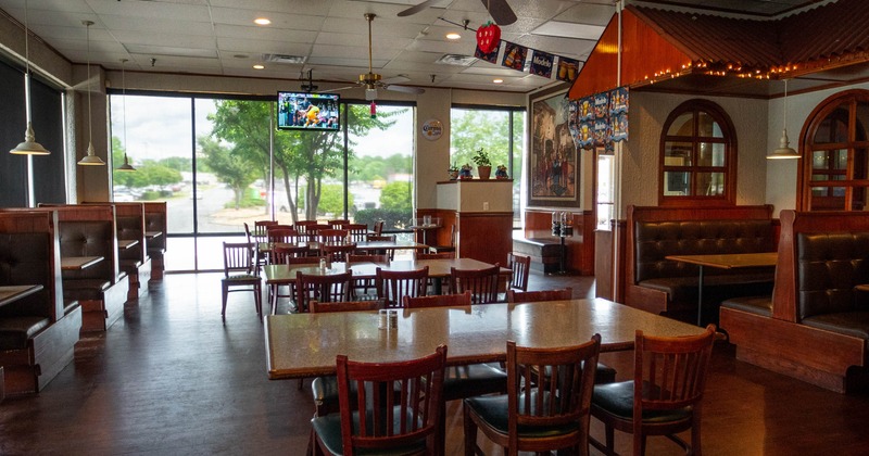 Interior, dining area, tables for six, seating booths, ceiling fans, large shop window in the back