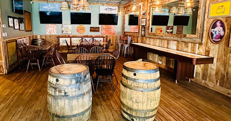 Cozy interior seating area with tables and chairs and two wooden barrel tables