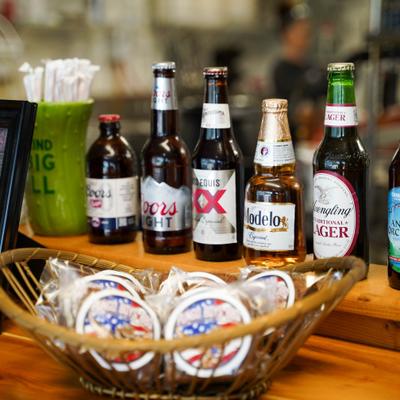 A selection of beer bottles displayed on a wooden counter with snacks.