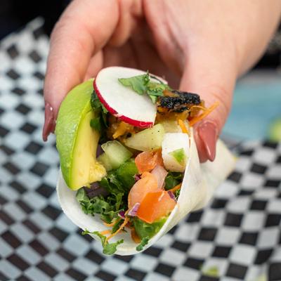 Maru's taco in hand, close up.