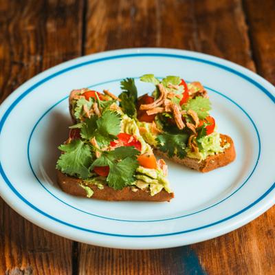 Avocado toast garnished with fresh herbs.