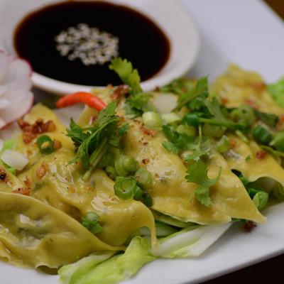 A serving of pork and ginger dumplings served with soy based ponzu.
