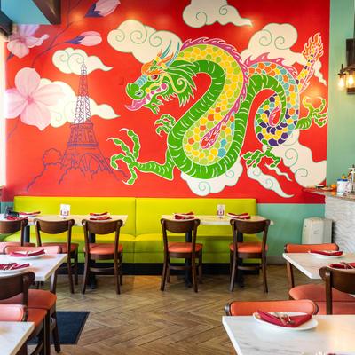 Interior, dining area with a large flying dragon mural art.